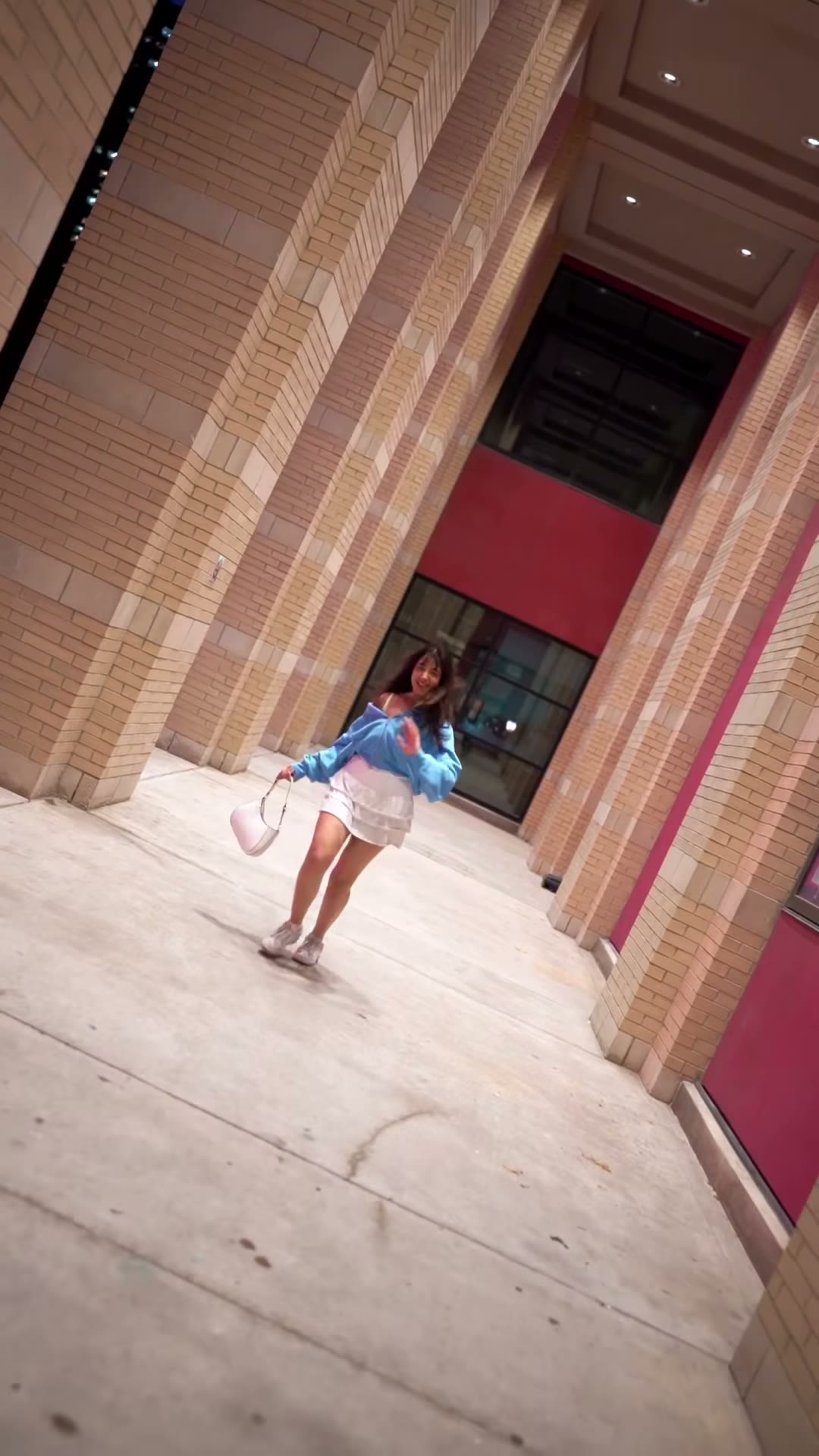 Dancer performing in a night-lit city corridor